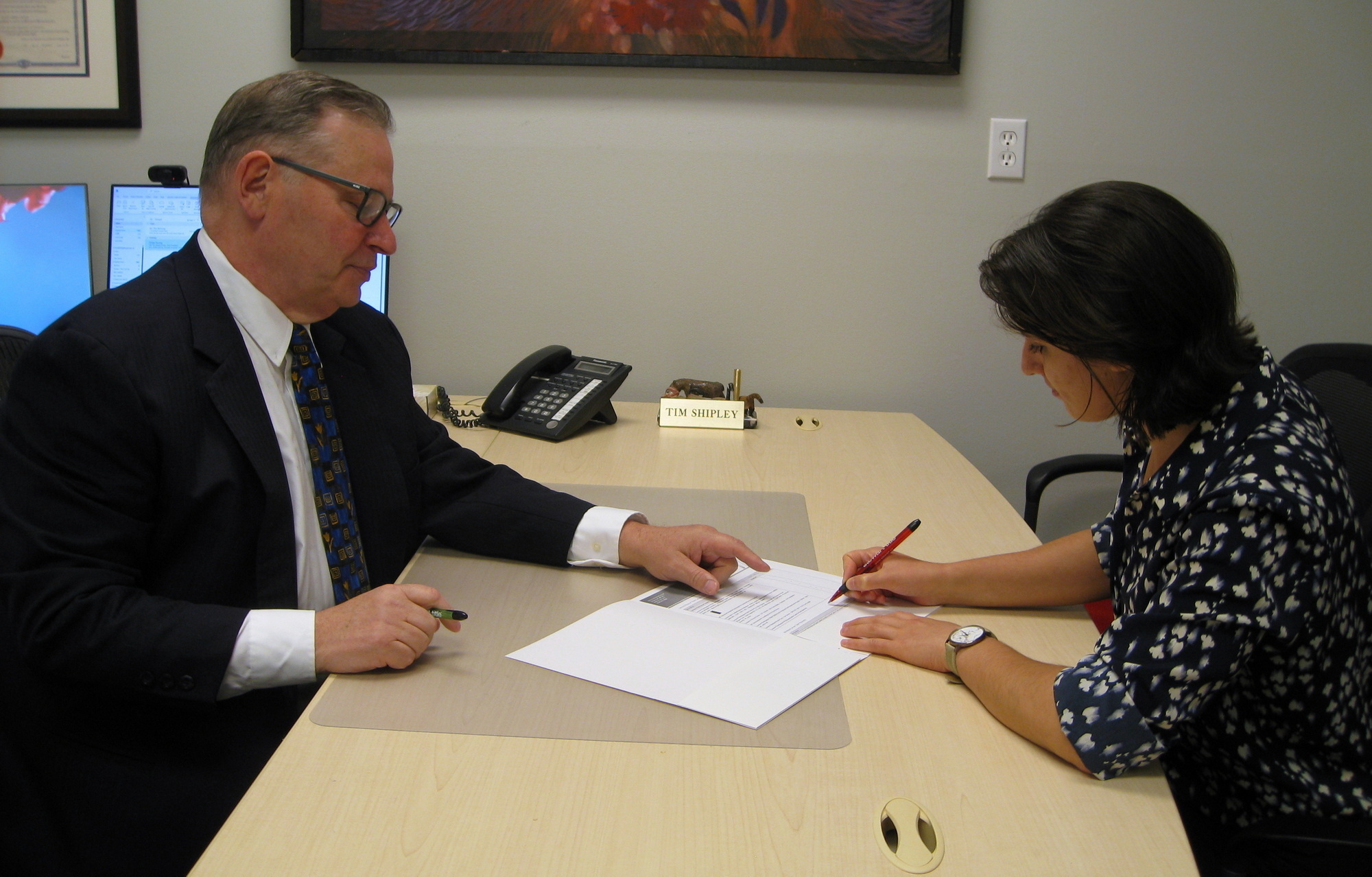 Tim Shipley and mock customer signing a will that they had just wrote and created.