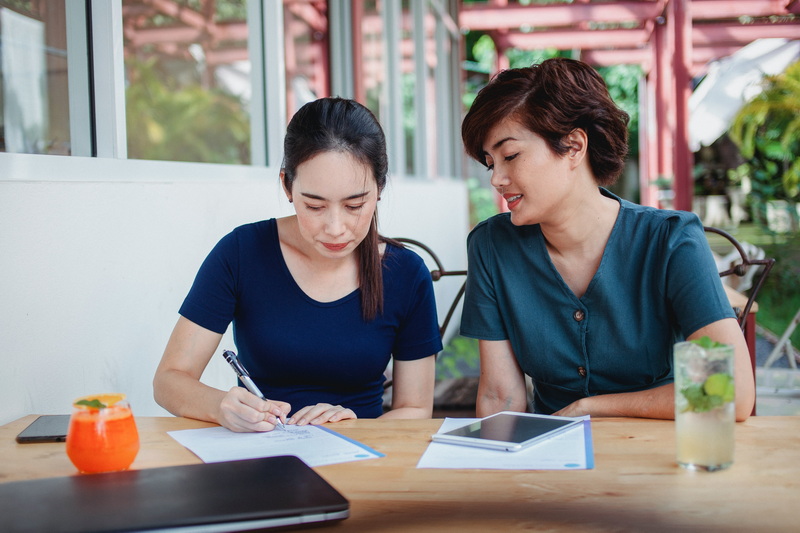 Two people signing a representation agreement in a relaxed environment